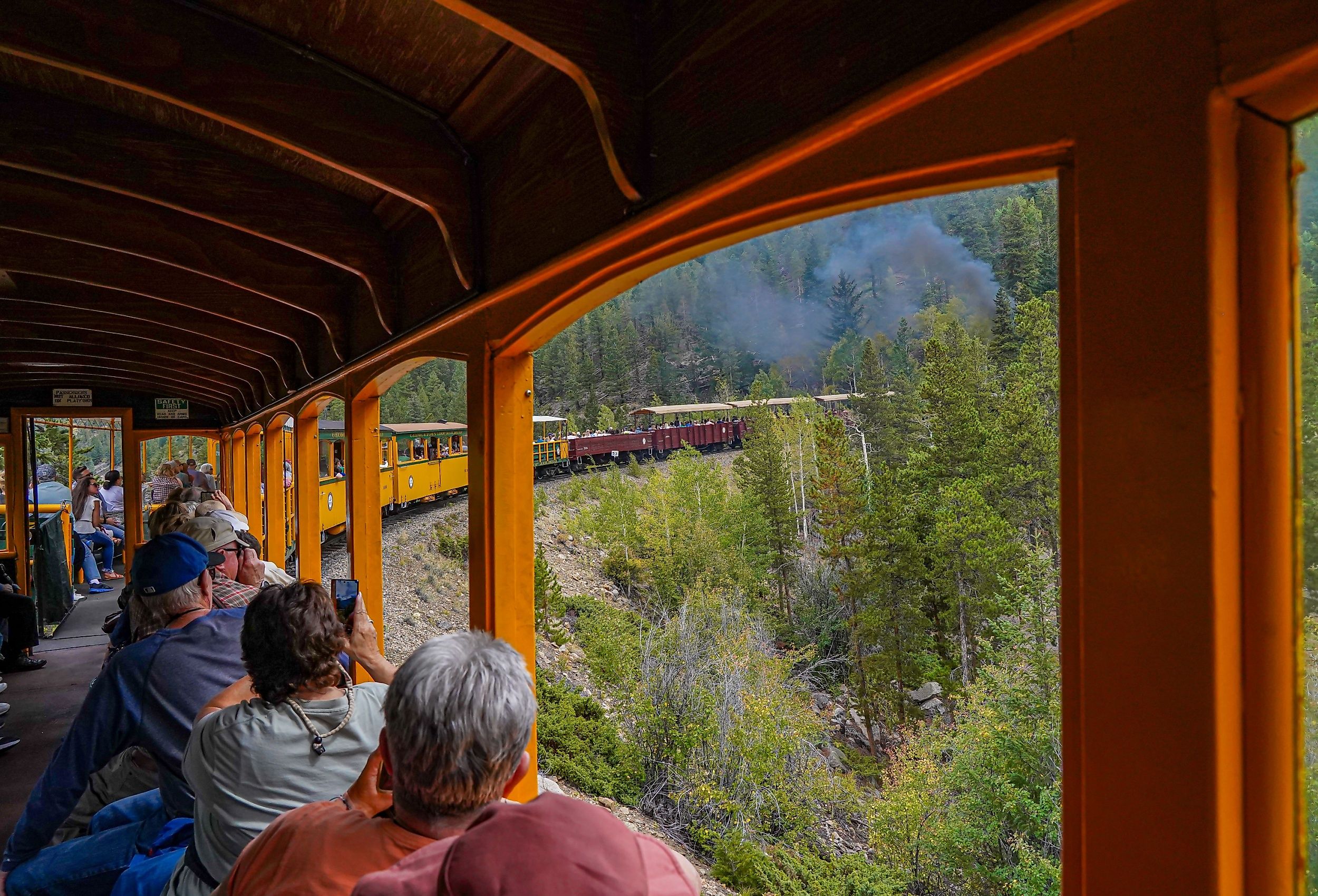 Tourists in a railroad car on the Georgetown Loop Railroad in Georgetown, Colorado. Image credit Bob Pool via Shutterstock.
