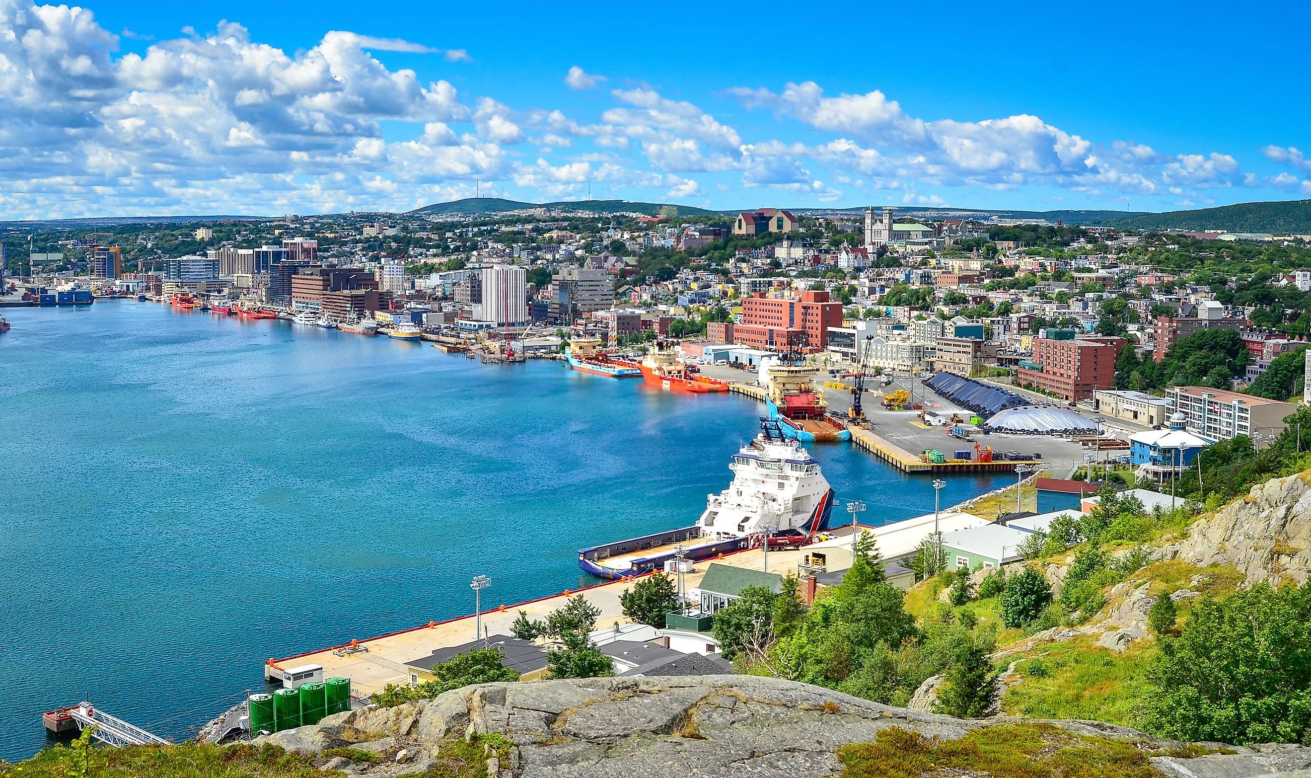 Panoramic views with bight blue summer day sky with puffy clouds over the harbor and city of St. John's NewFoundland