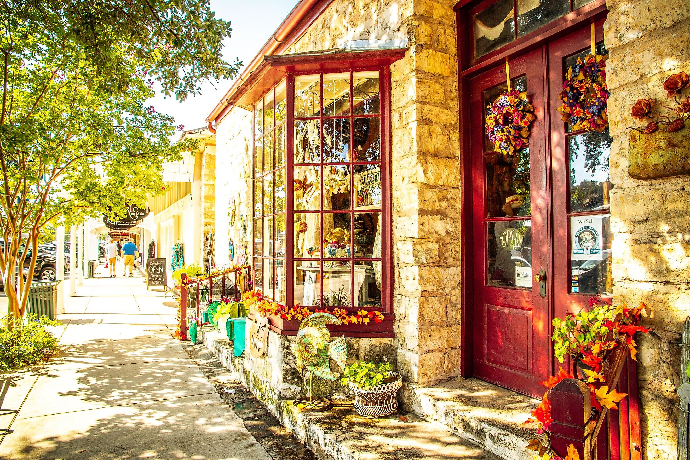 View from the sidewalk, looking at a colorful store adorned with flowers on Main Street in Fredericksburg, Texas, USA, known as "The Magic Mile." Editorial credit: ShengYing Lin / Shutterstock.com