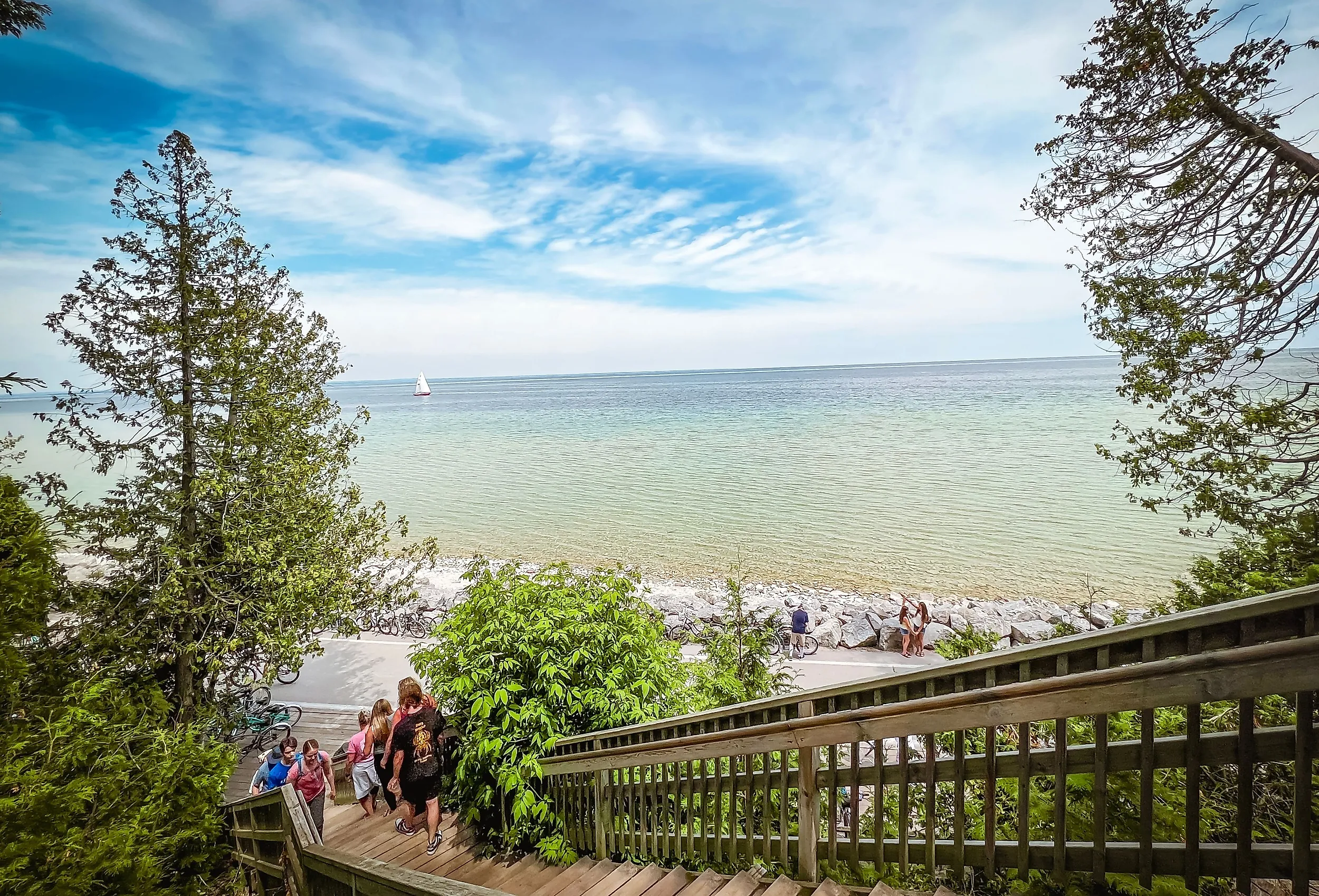 Wooden stairway leading through the forest to the Arch Rock natural limestone formation in Mackinac Island. Image credit: Sanya Kushak via Shutterstock.