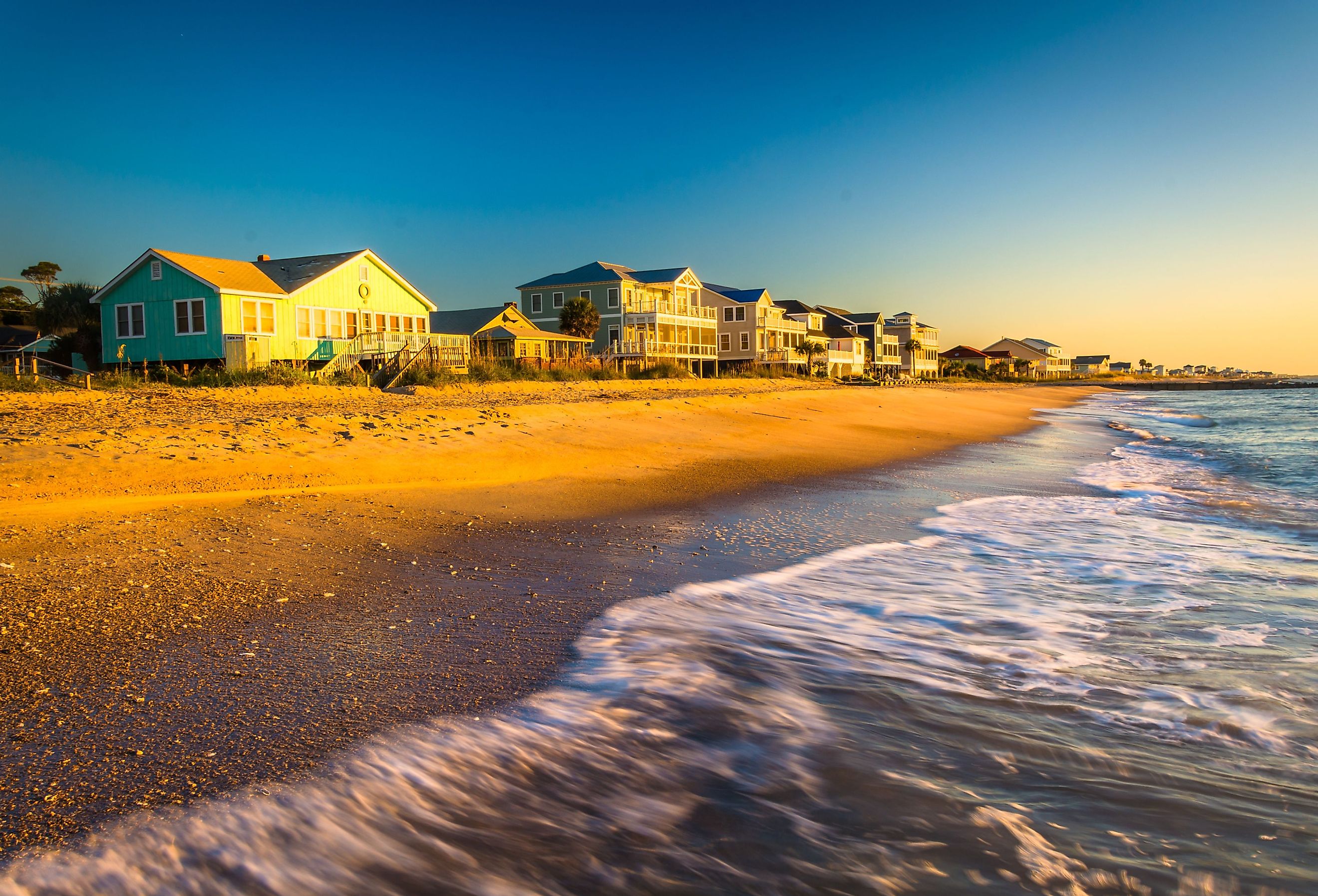 Waves in the Atlantic Ocean and morning light on beachfront homes at Edisto Beach, South Carolina.