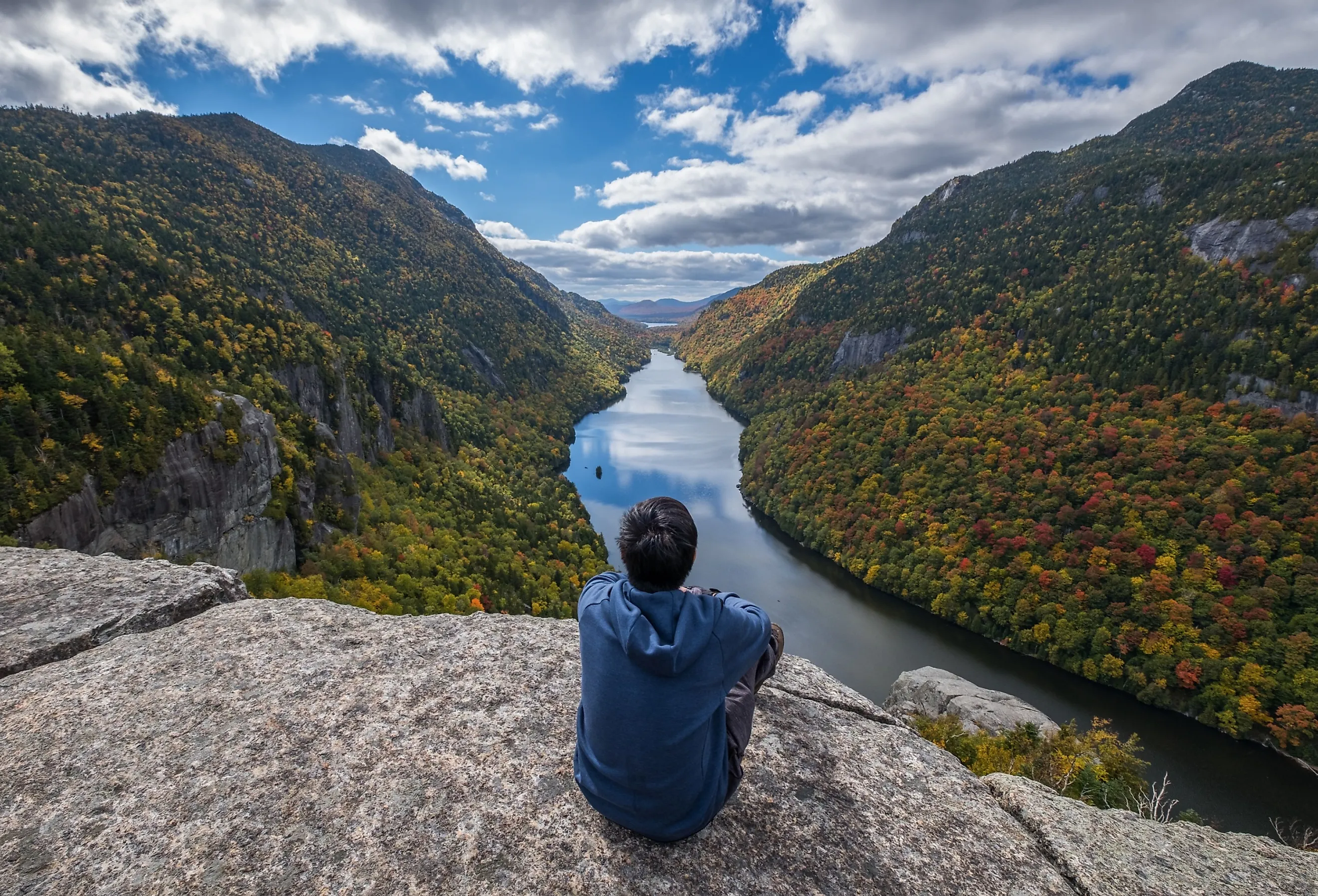 Man sitting on Indian Head Cliff at Adirondack Park, New York, USA
