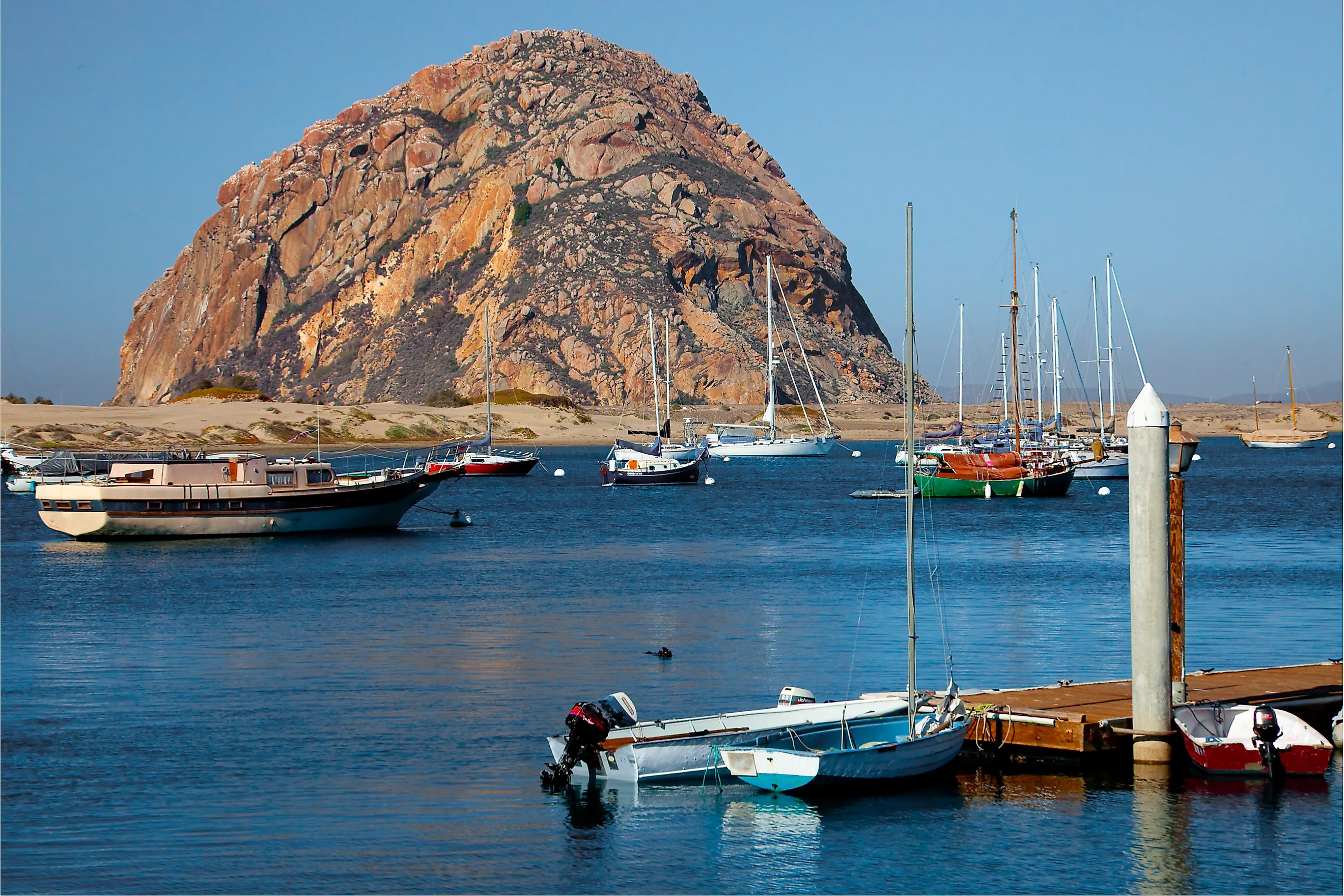  View of boats and Morro Rock along the coast of Morro Bay in California.
