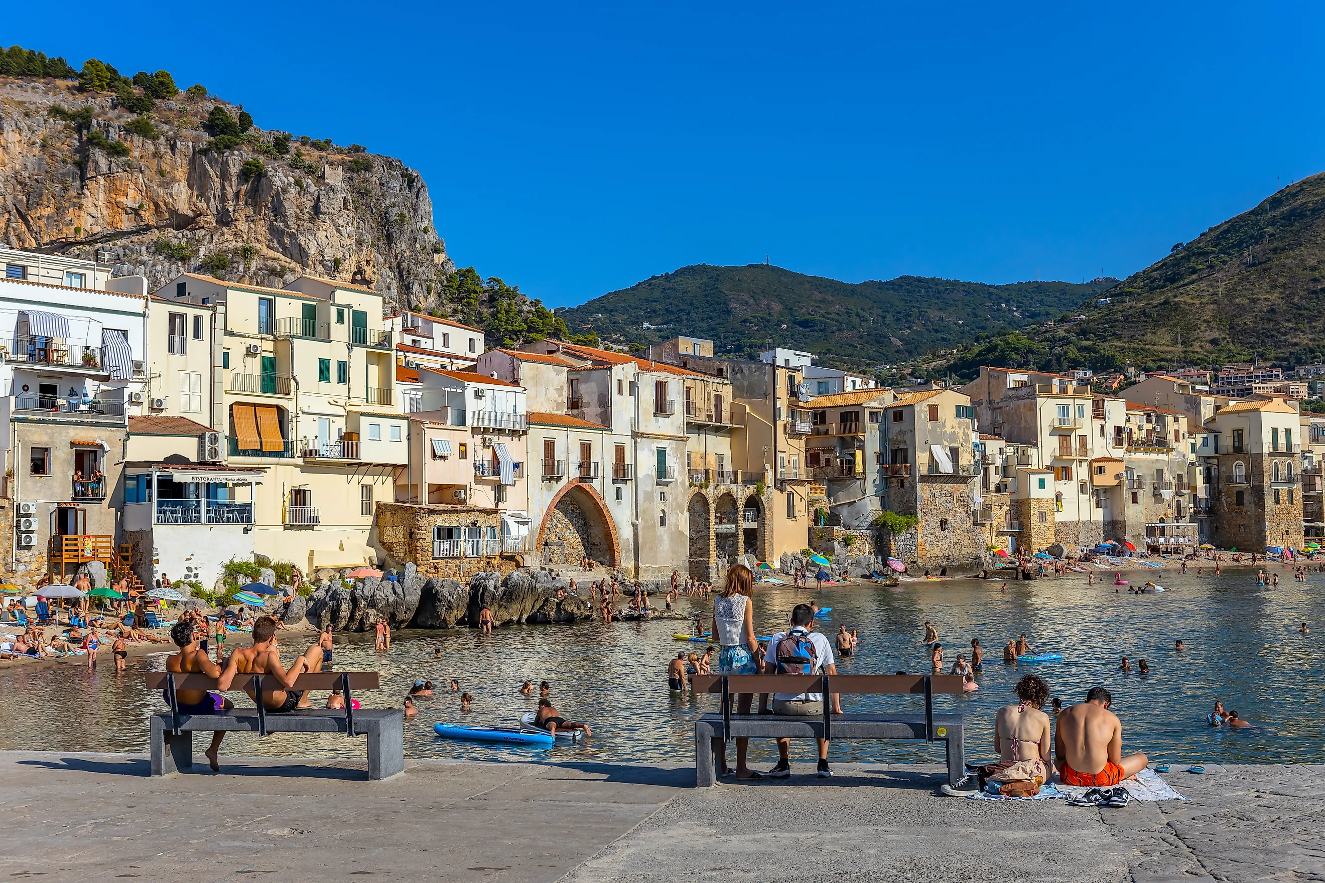 People enjoying by the beachside in Cefalù, Italy.