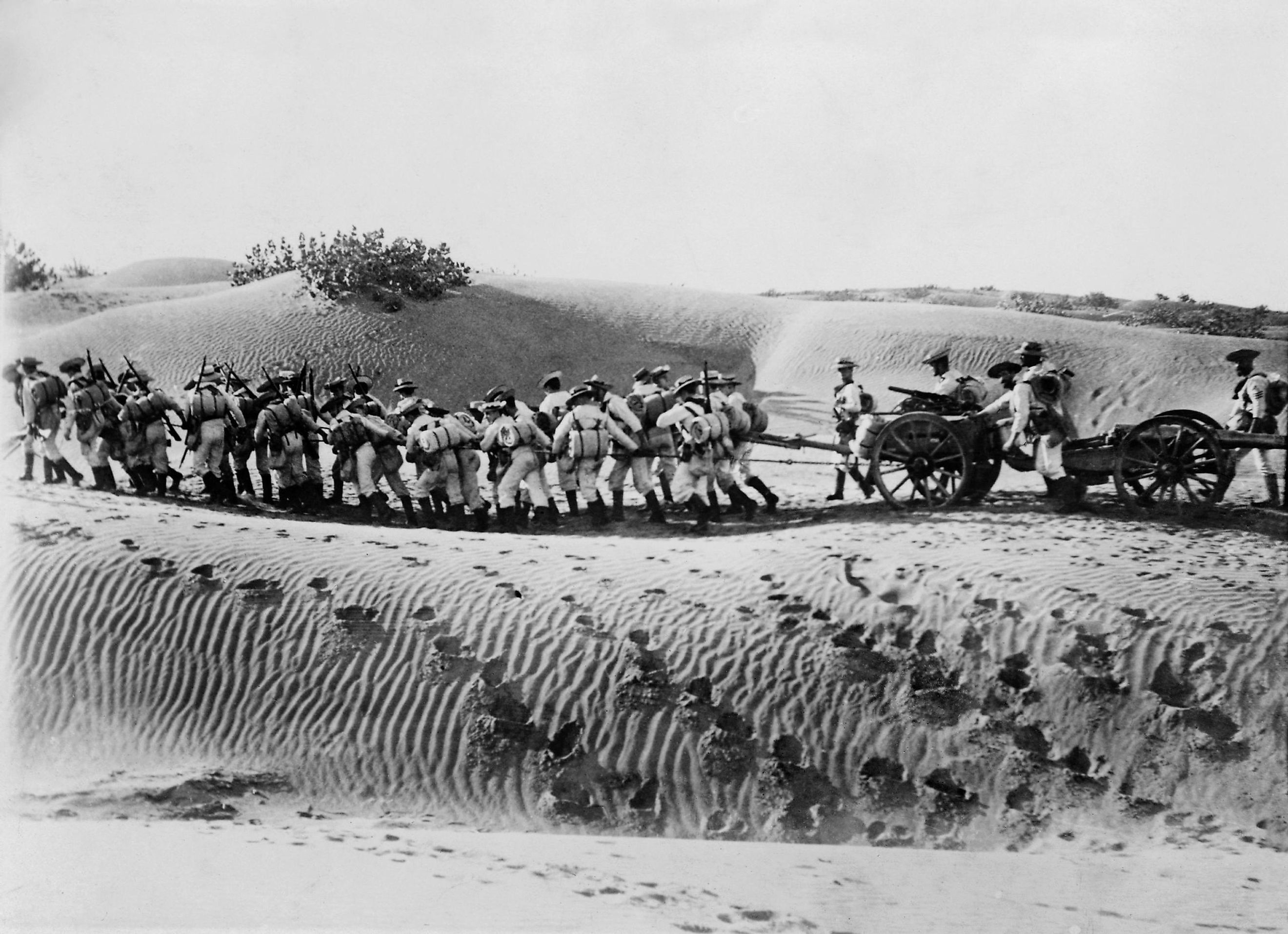 British naval landing party pulling field gun and caisson across the desert. Shutterstock.