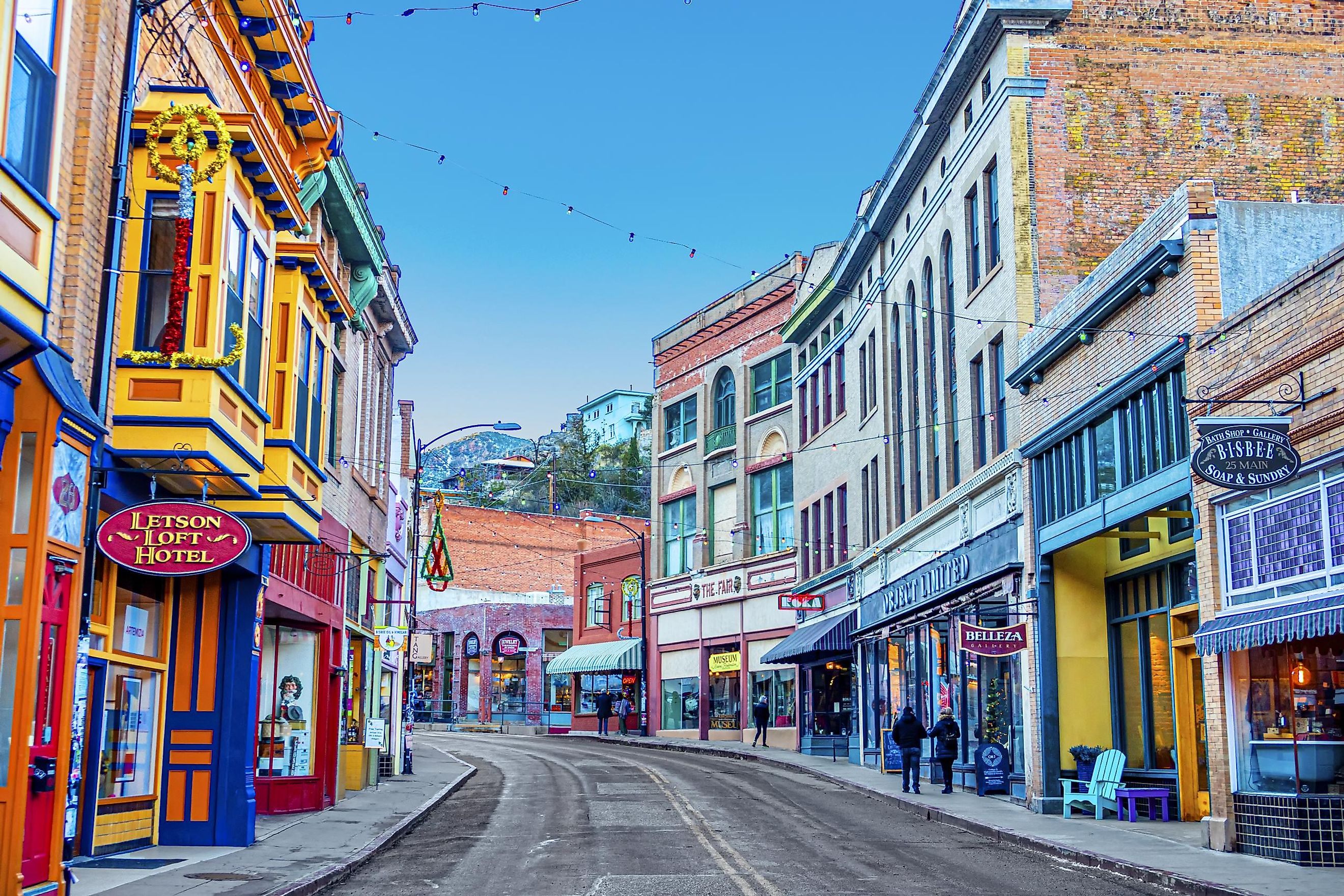 Buildings lining Main Street on a clear day at the edge of Bisbee, Arizona