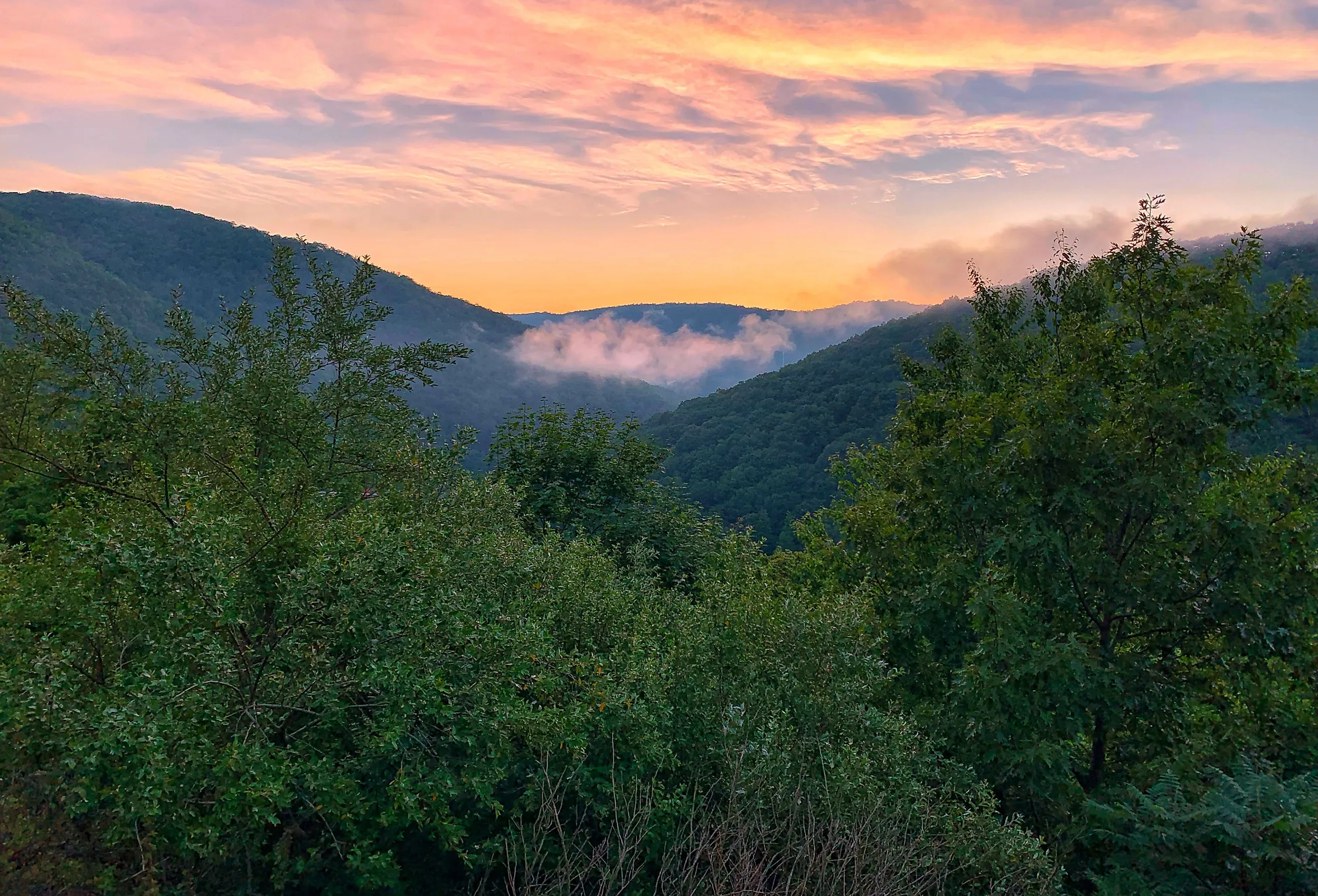 A colorful sunset sky above the cool, cloudy Pocono Mountains in Pennsylvania. Image credit Quinn Kampschroer via Shutterstock. 