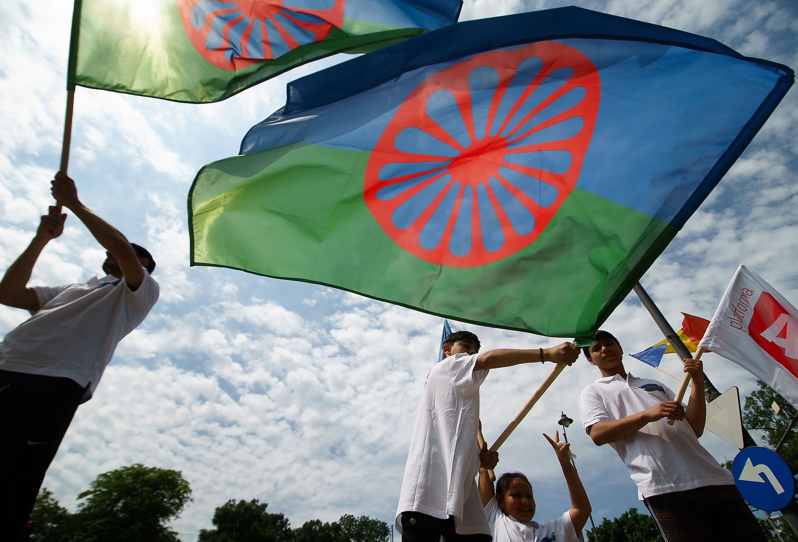 Roma activists wave the Romanian flag and protest in front of the Russian embassy. Image credit LCV via Shutterstock