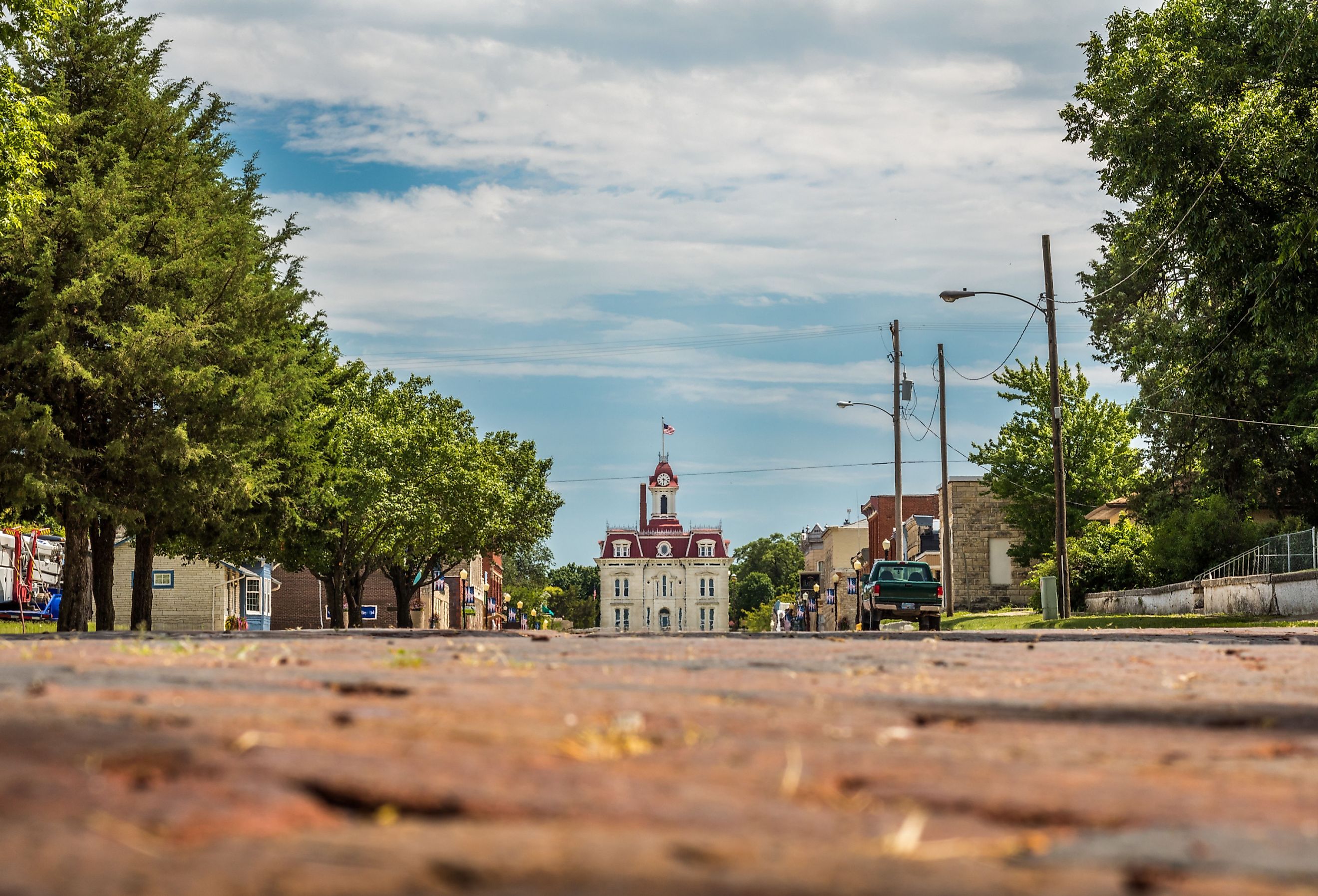 Horizontal photo of downtown area of Cottonwood Falls, KS with the courthouse at the end of the street. Image credit fletchjr via Shutterstock. 