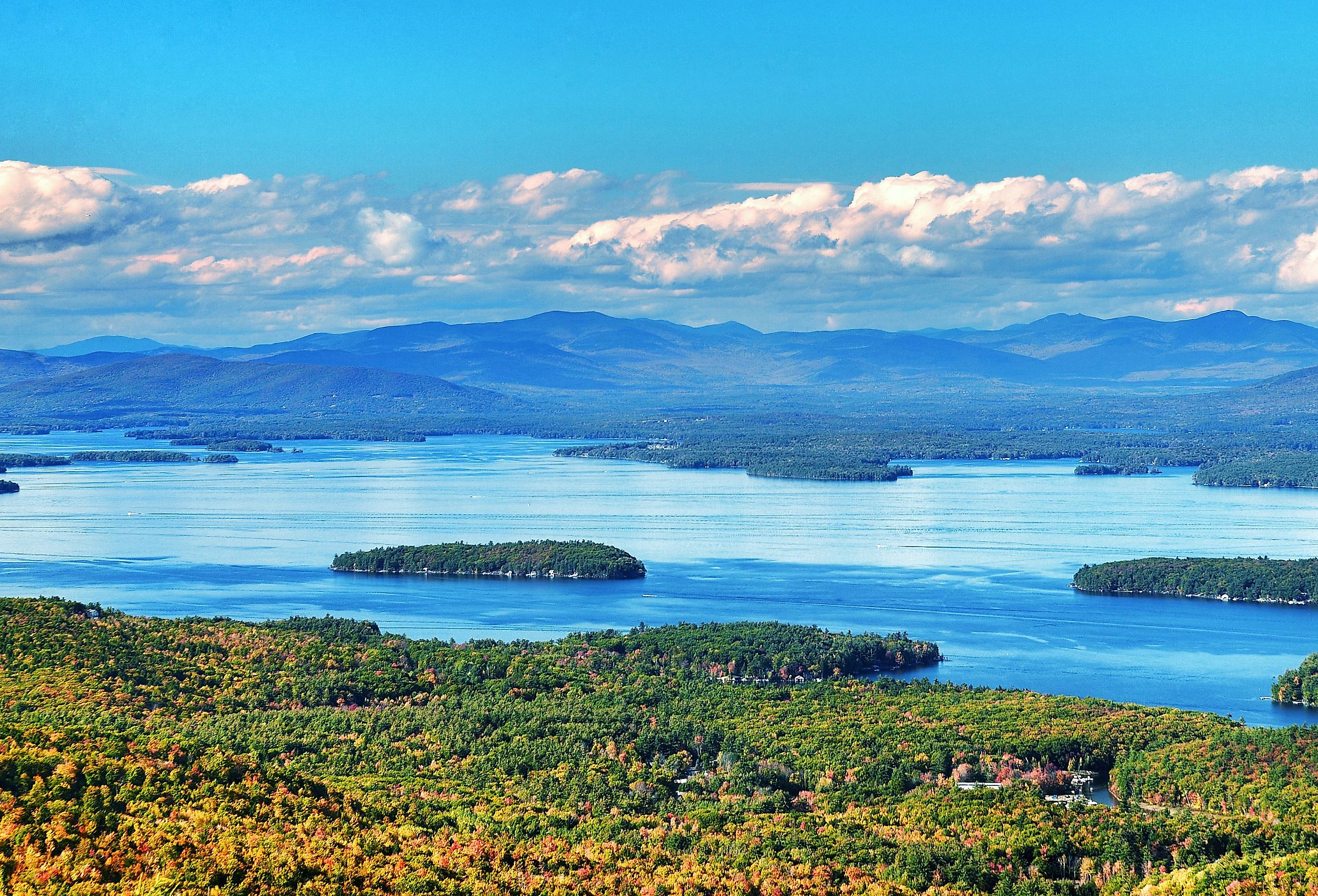 Aerial view of Lake Winnipesaukee, New Hampshire with mountains in the distance.