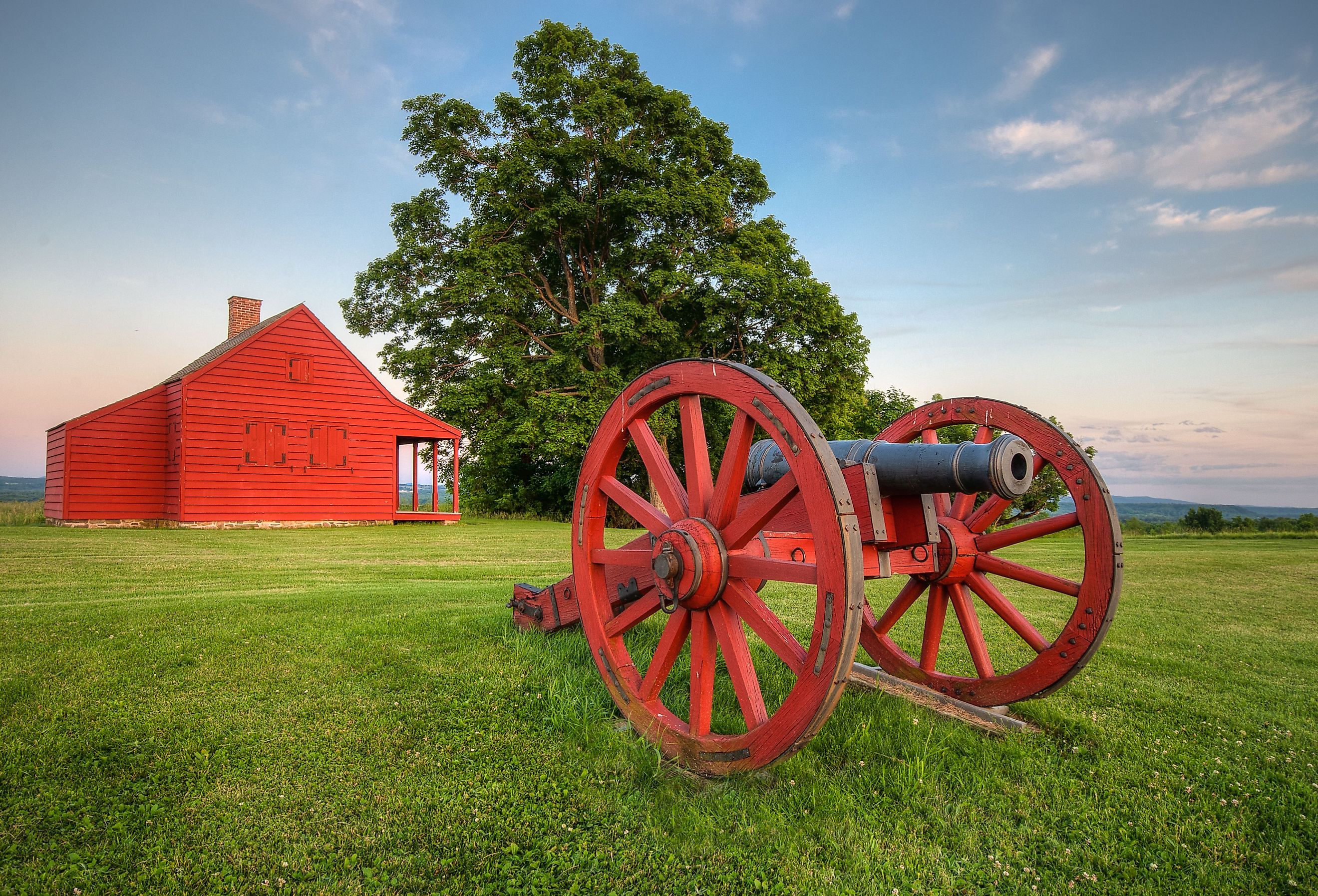 Cannon at Saratoga National Battlefield with Neilson Farm in the background.