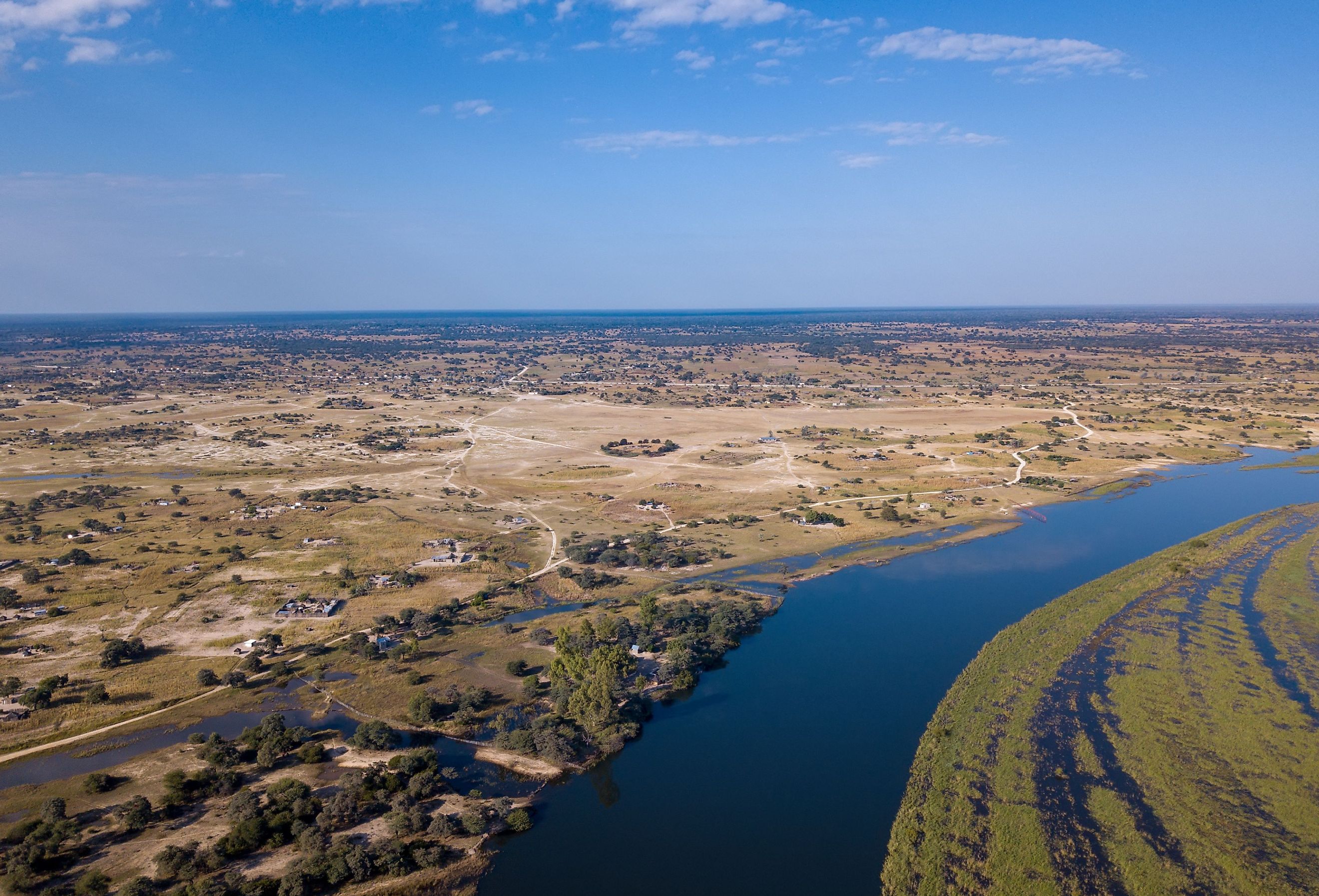 Aerial landscape in Okavango delta on Namibia and Angola border. River with shore and green vegetation after rainy season. Image credit Artush via Shutterstock. 