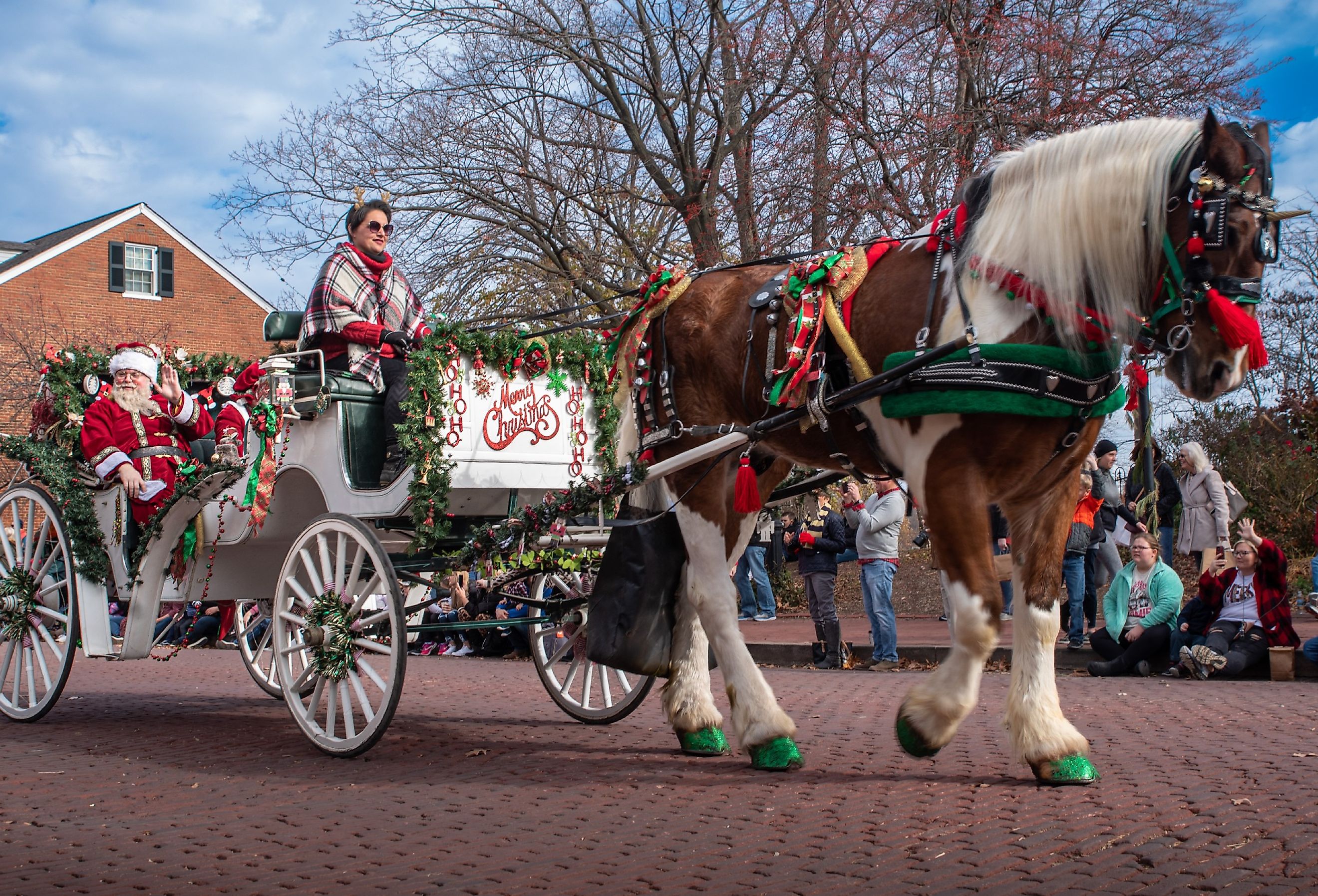 Santa and Mrs Claus wave from a horse drawn carriage in the Christmas and Holiday parade in Saint Charles, Missouri. Image credit RozenskiP via Shutterstock