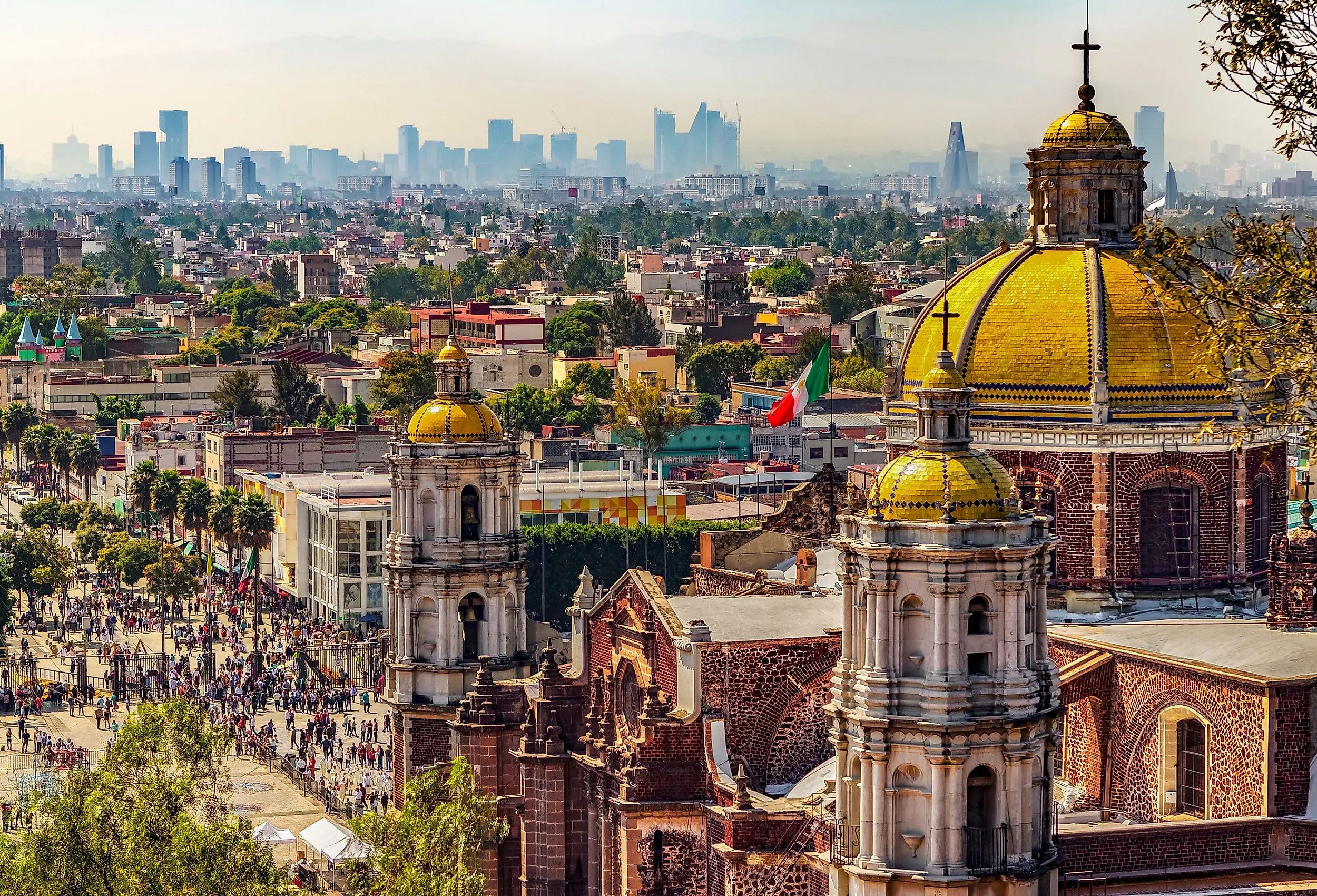 Mexico. Basilica of Our Lady of Guadalupe. Cupolas of the old basilica and cityscape of Mexico City. Image credit WitR via Shutterstock