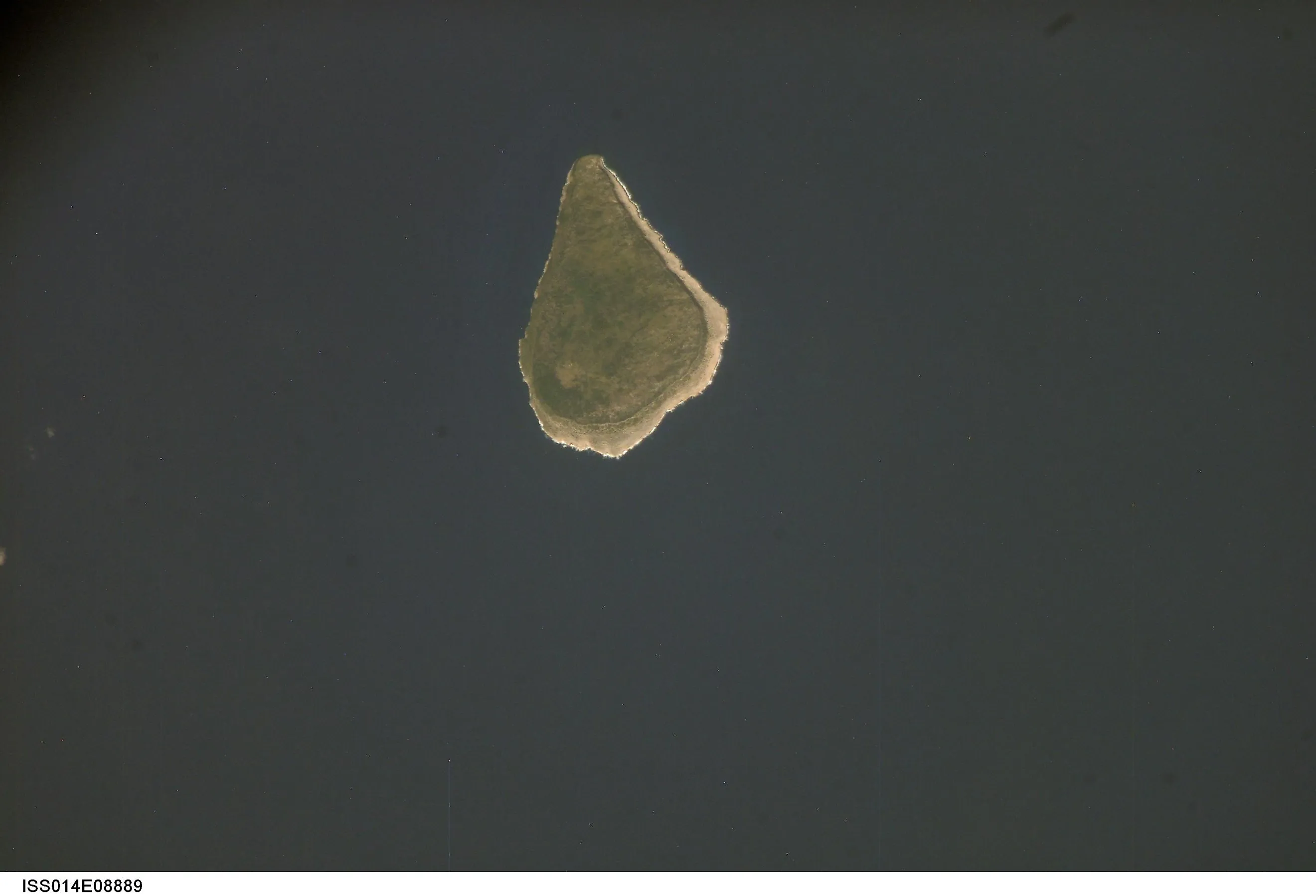 Astronaut photo of teardrop-shaped Navassa Island. The island is basically a plateau encircled by fairly steep cliffs.