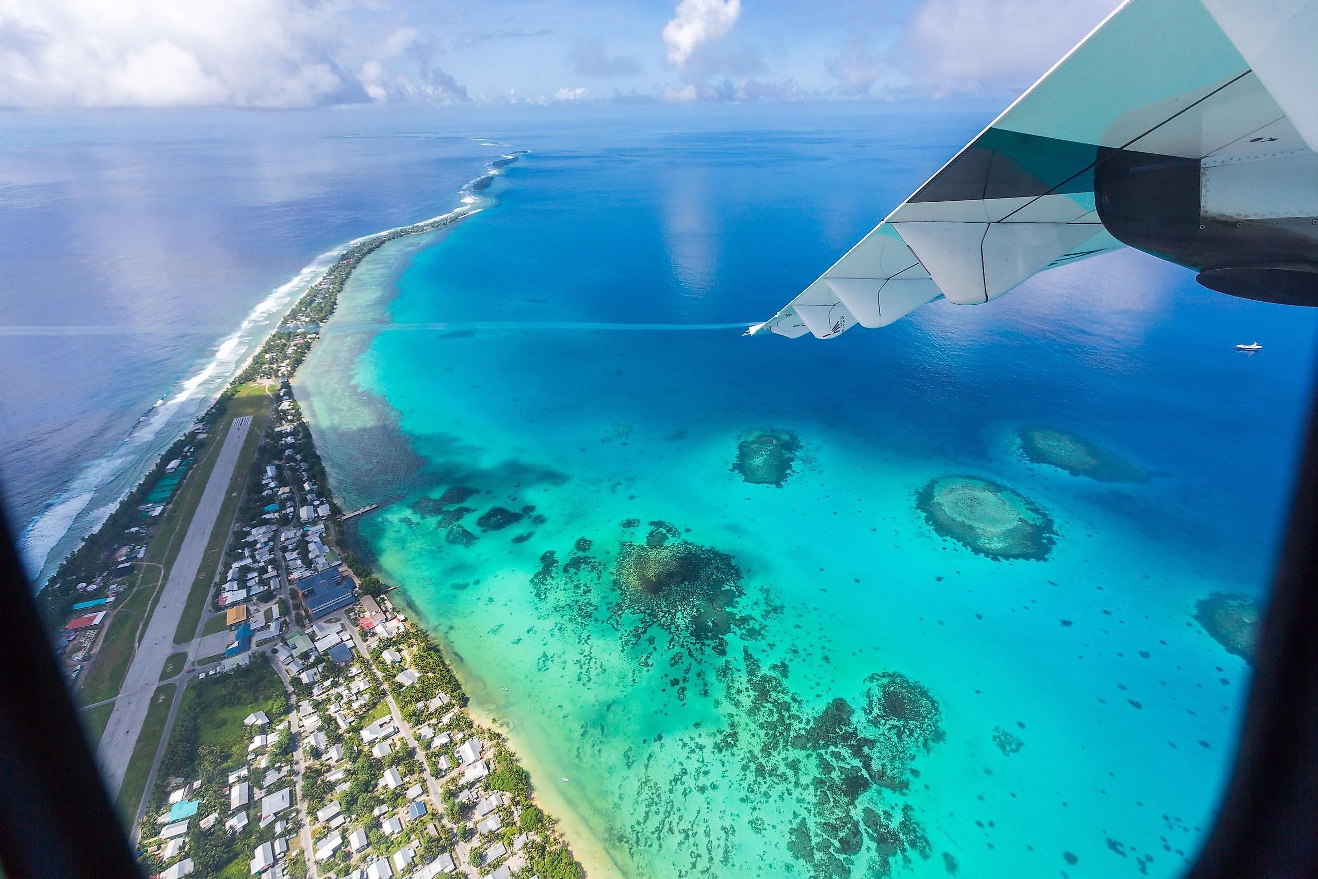 Tuvalu island lagoon under the wing of an airplane.