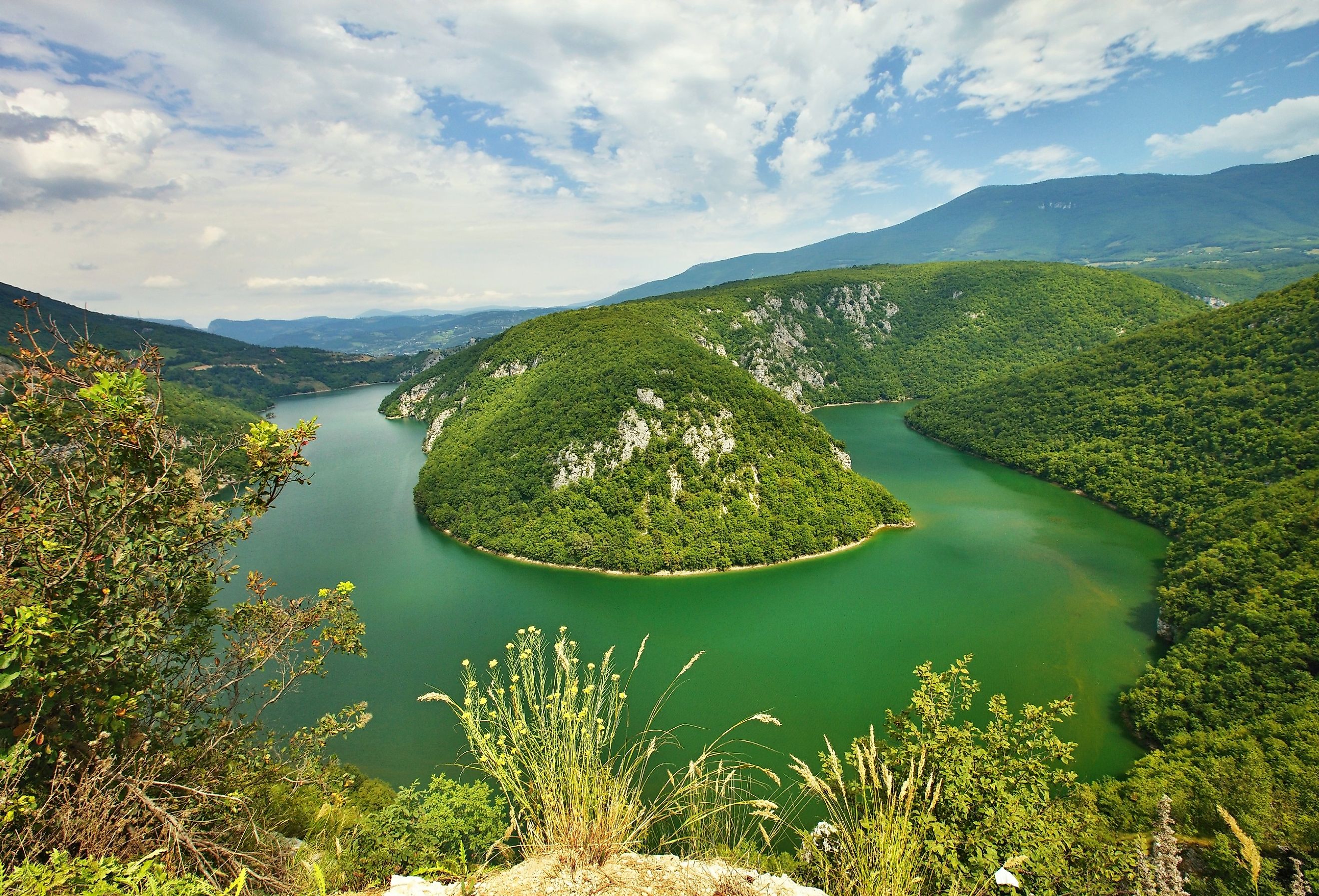 Aerial photo of the green waters of the bending Drava River through Slovenia.