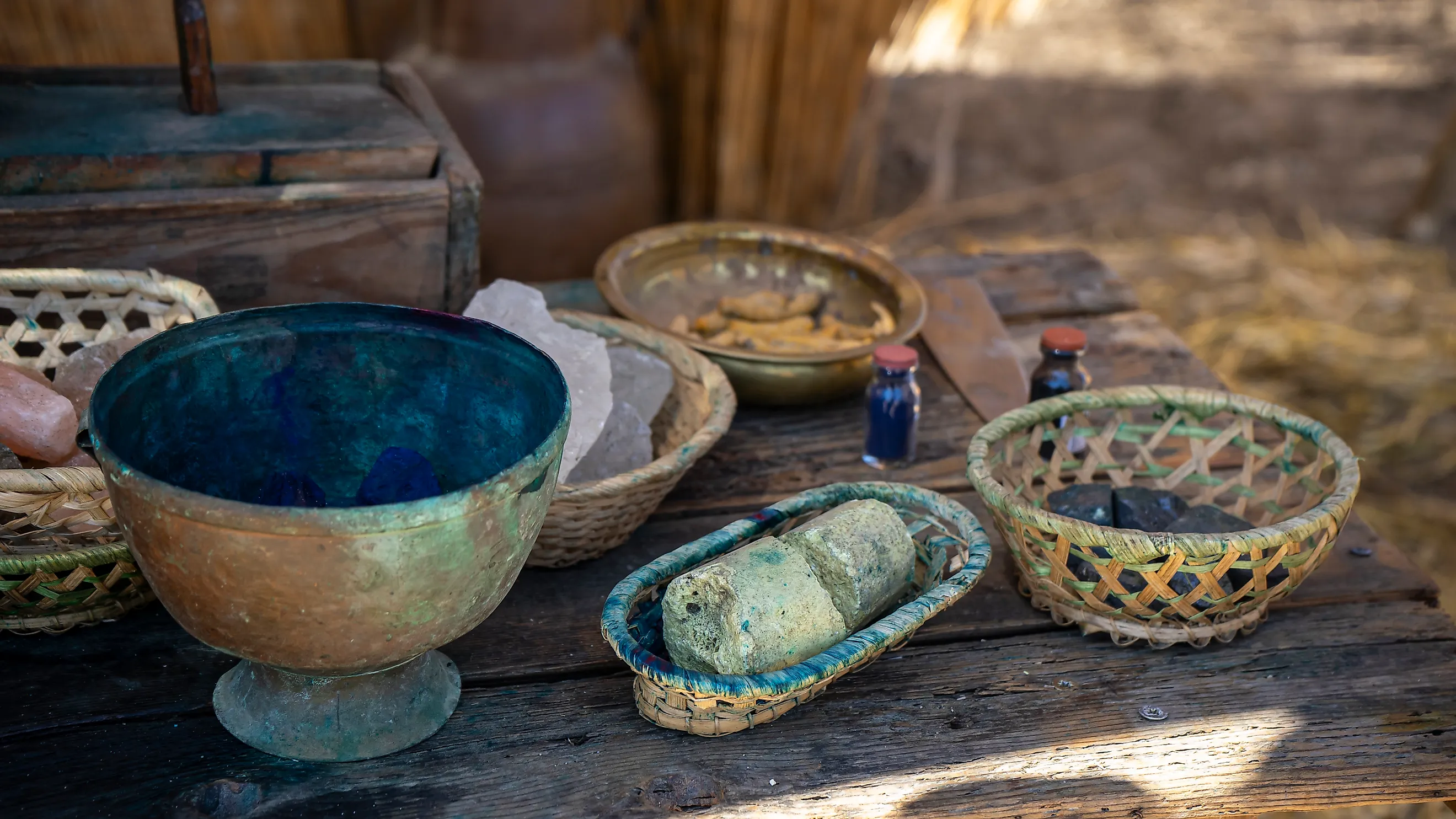 Ancient valuables in various bowls and containers on a wooden table.
