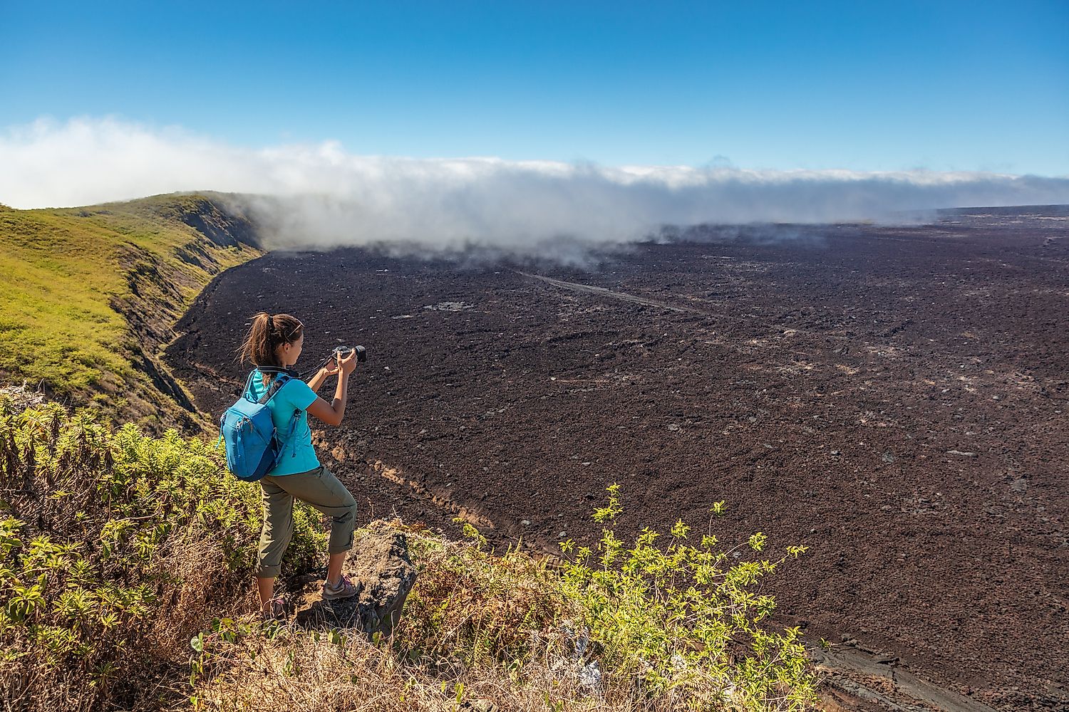 Galapagos tourist hiking on volcano Sierra Negra on Isabela Island. Image credit: Maridav/Shutterstock.com