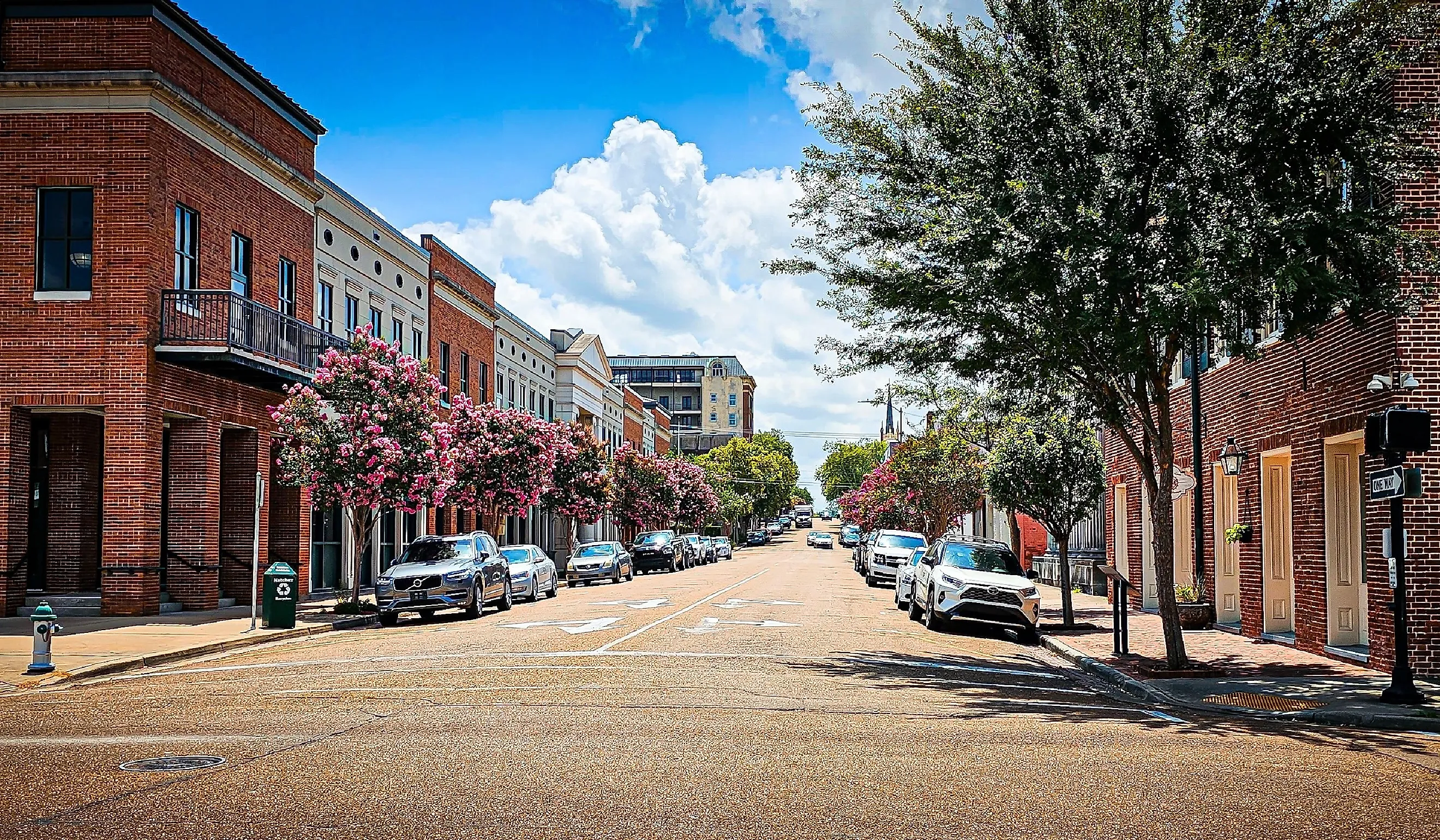 Cars are parked along the city street in downtown Natchez on a summer day. Editorial credit: VioletSkyAdventures / Shutterstock.com
