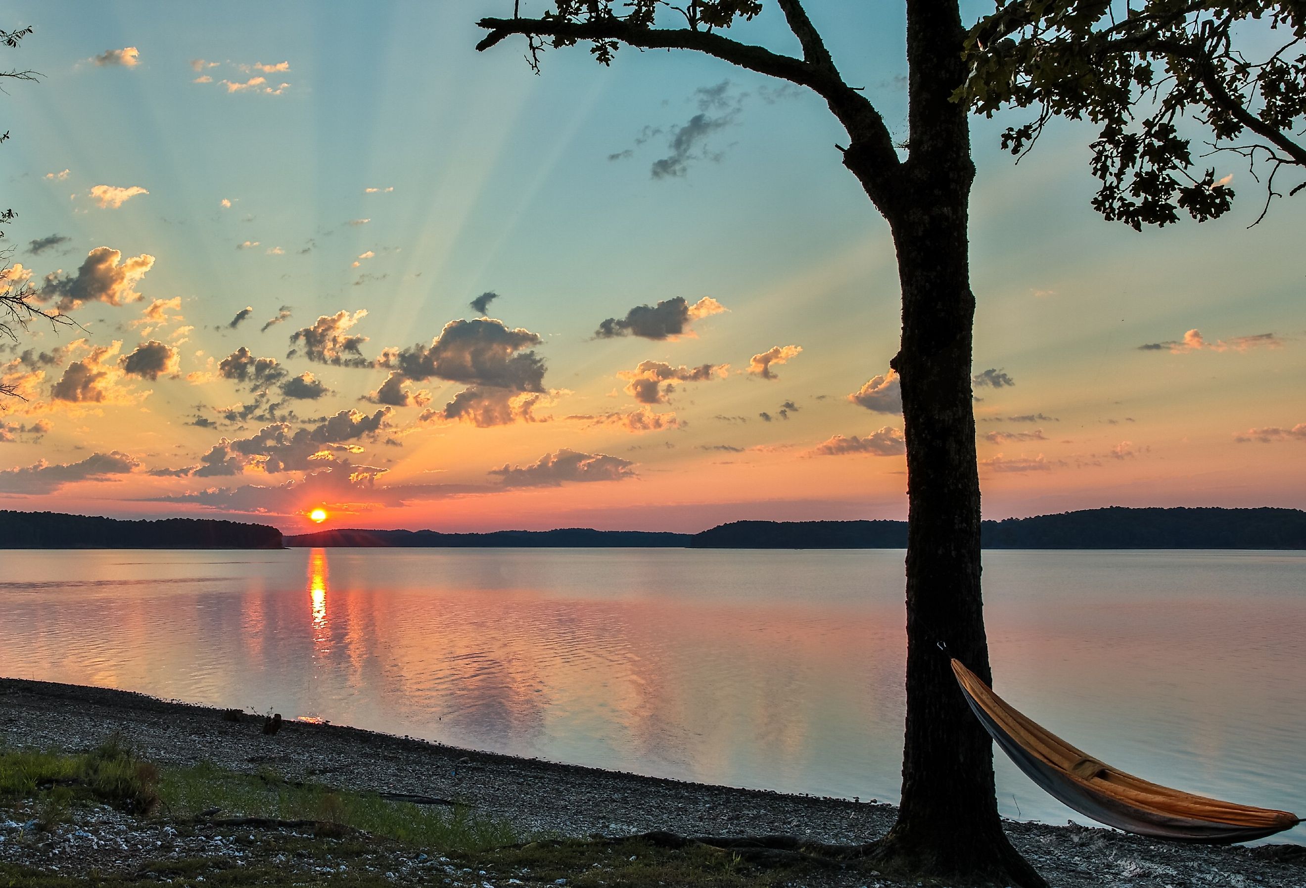 Hammock on rock beach looking over a beautiful sunrise at lake Ouachita, Arkansas.