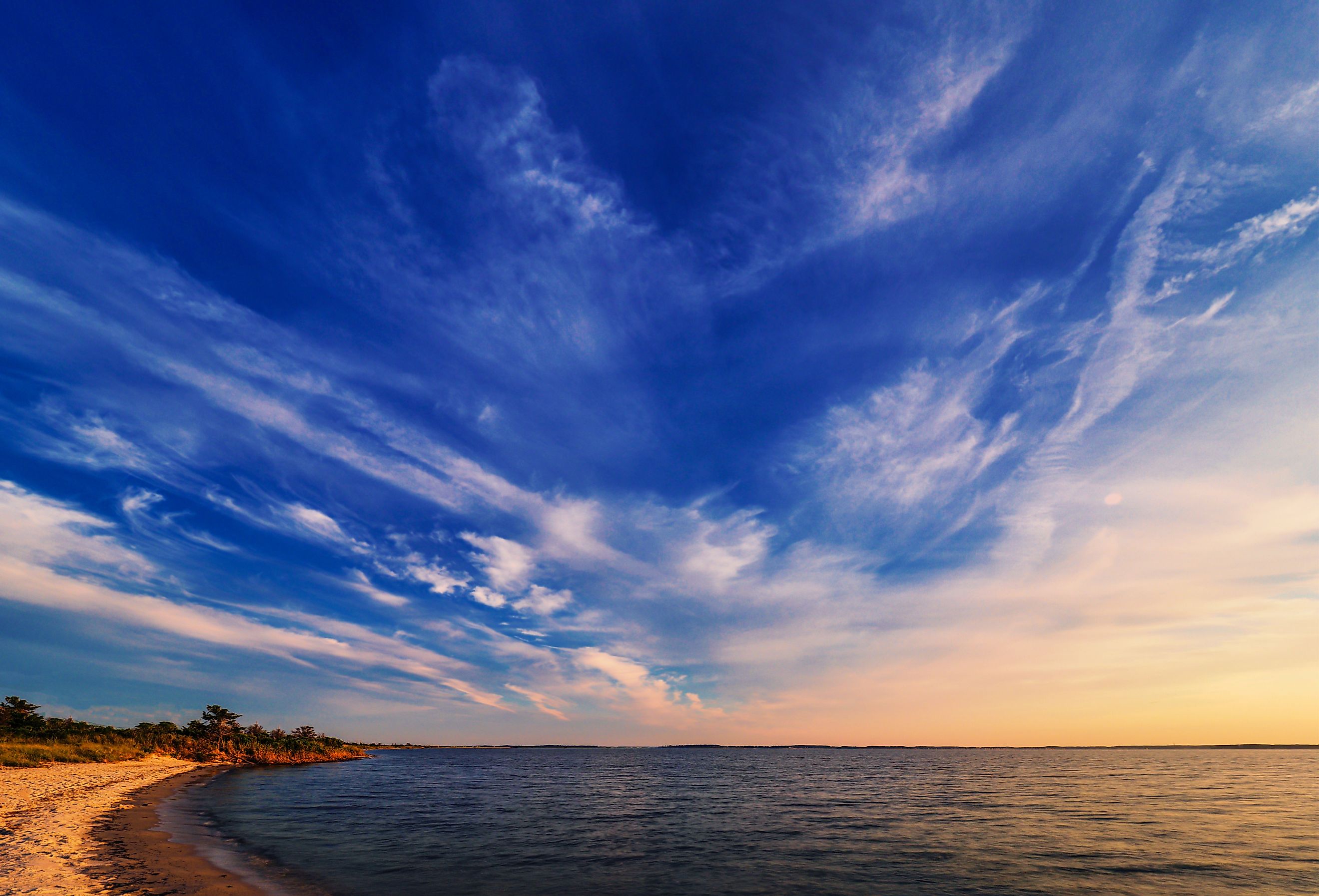 As twilight begins a dramatic sky unfolds before an empty beach at Rehoboth Bay, Delaware. Image credit David Kay via Shutterstock.