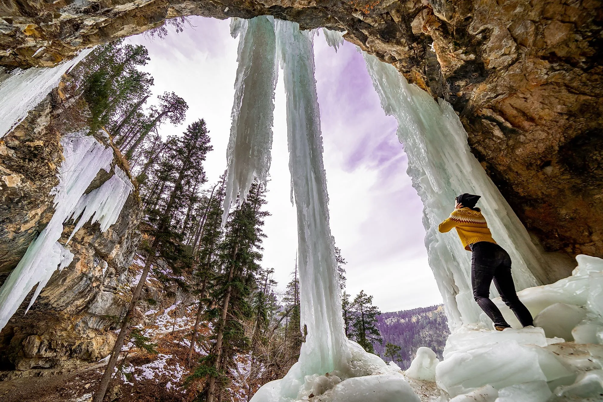 A girl standing under a frozen waterfall in Spearfish, South Dakota.