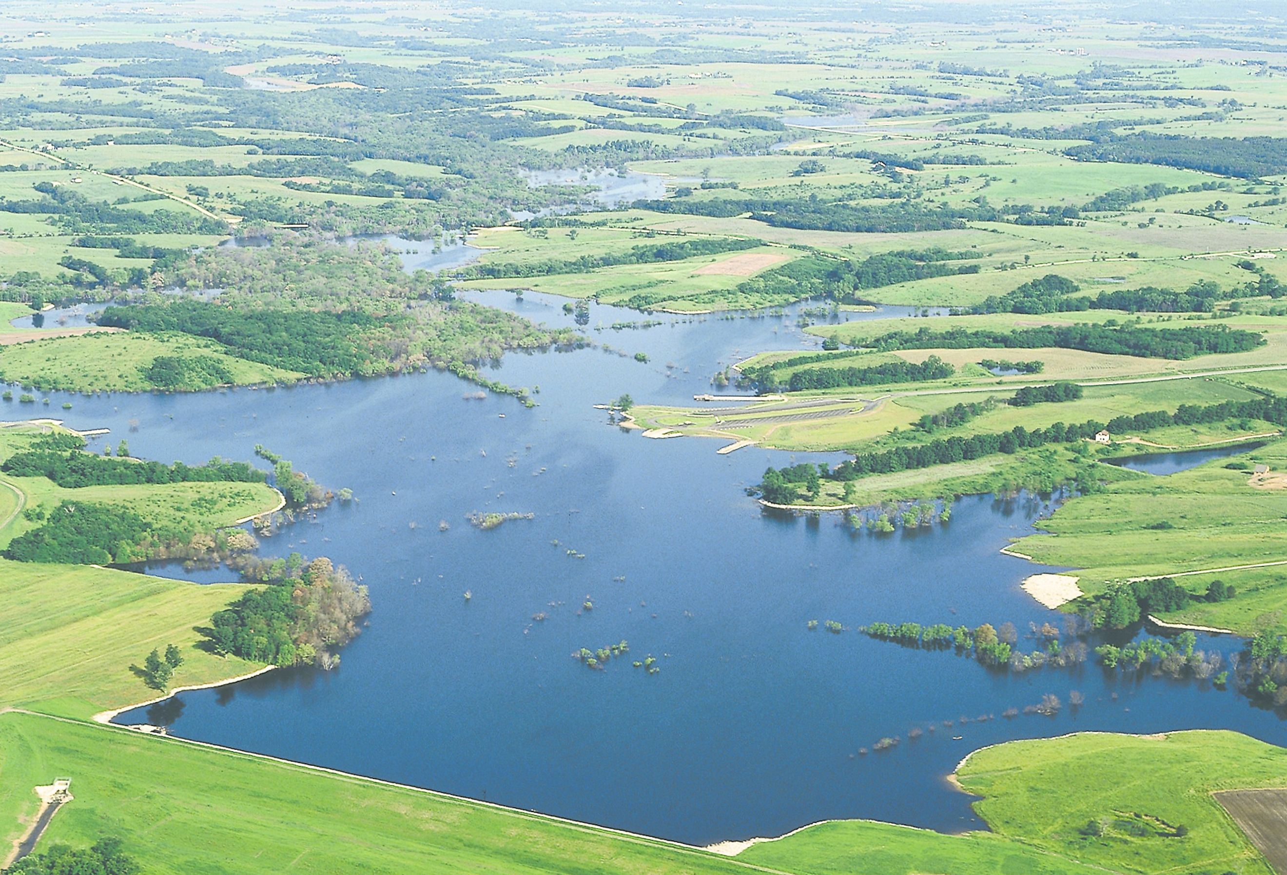 Aerial view of Lake Sugema surrounded by lush grass and trees.