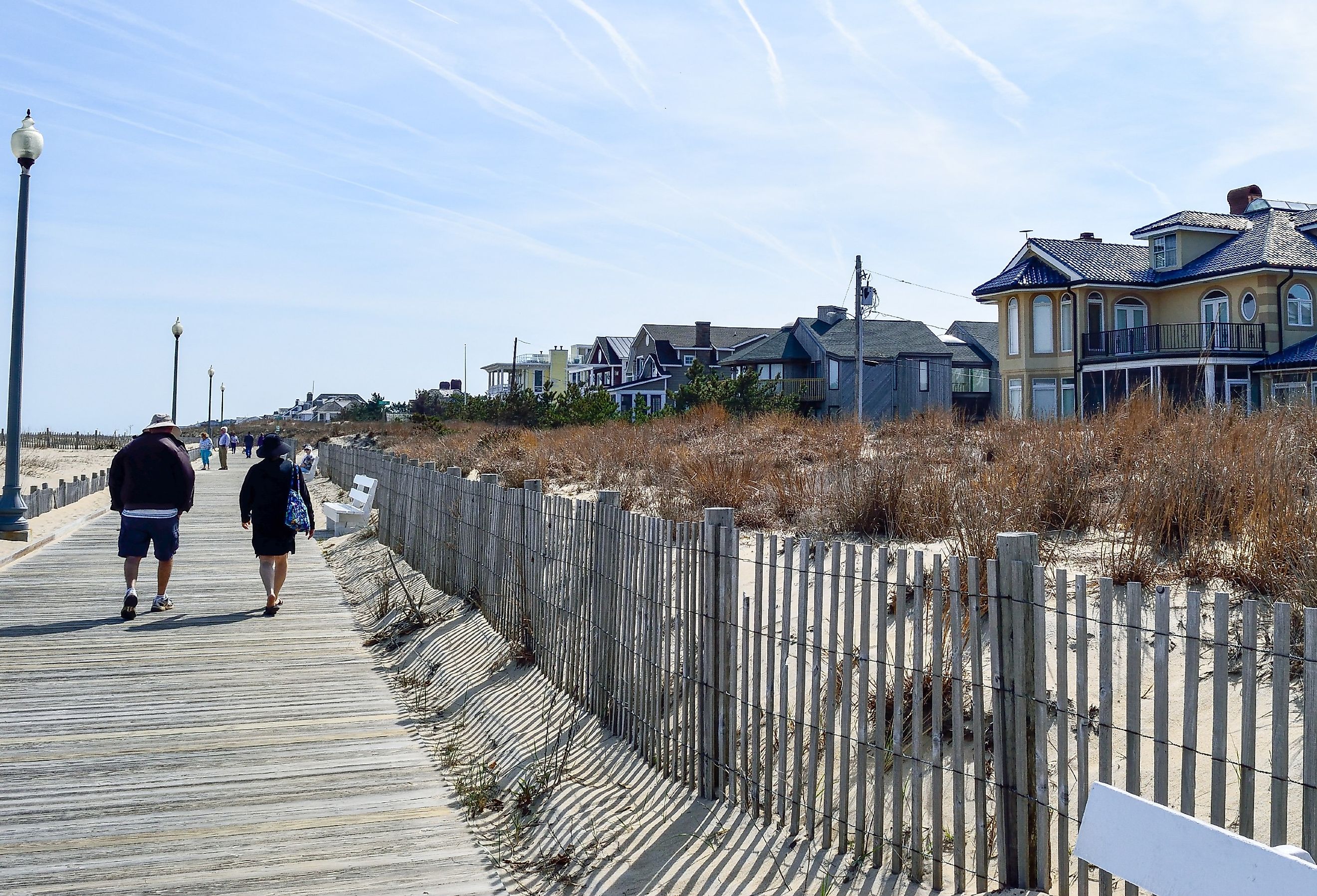 People walking along the boardwalk by the beach in Rehoboth Beach, Delaware.