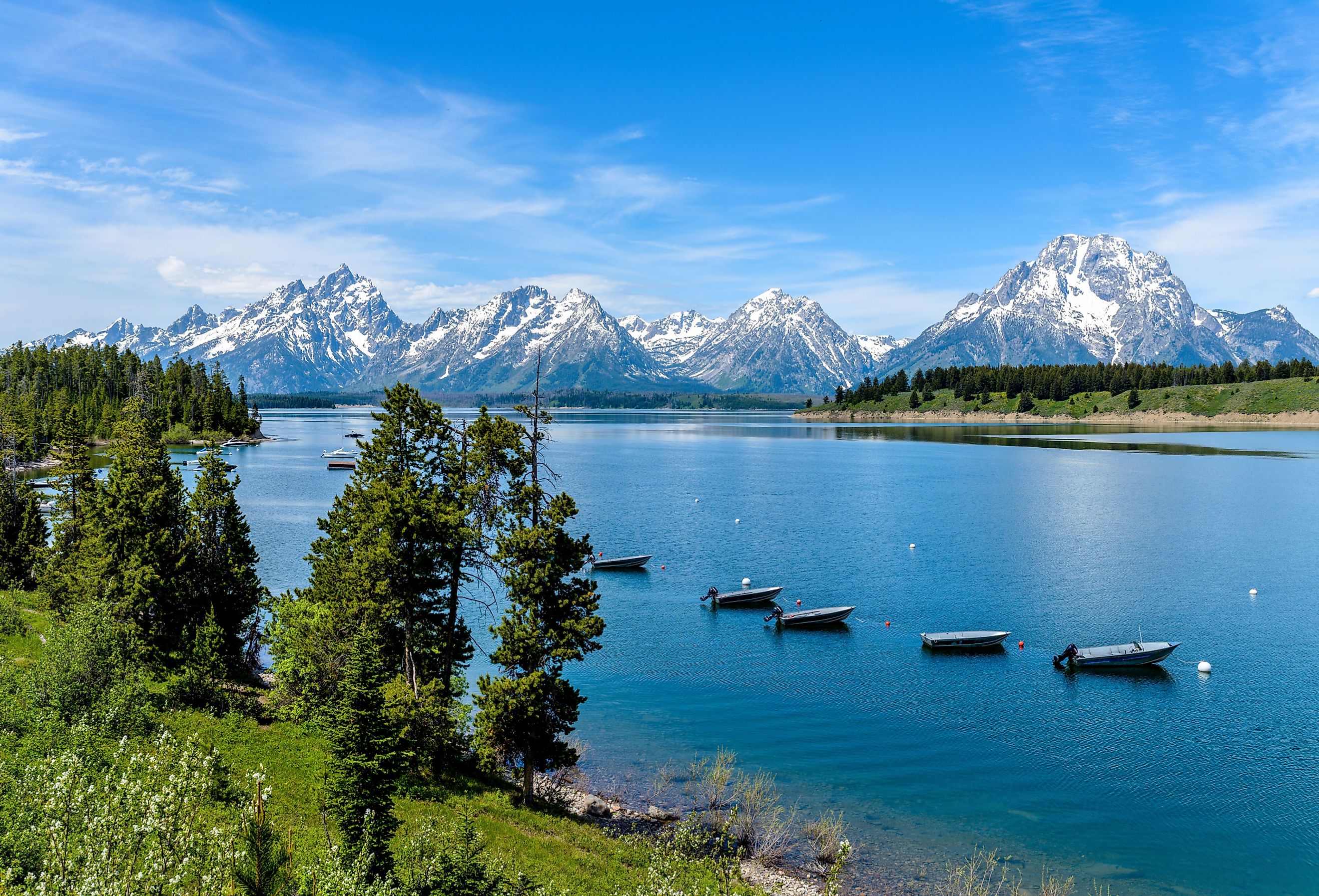 Spring view of a quiet bay of Jackson Lake, with Teton Range rising in the background, Grand Teton National Park, Wyoming.