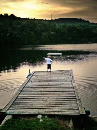 A Boy Fishing from the End of a Small Pier