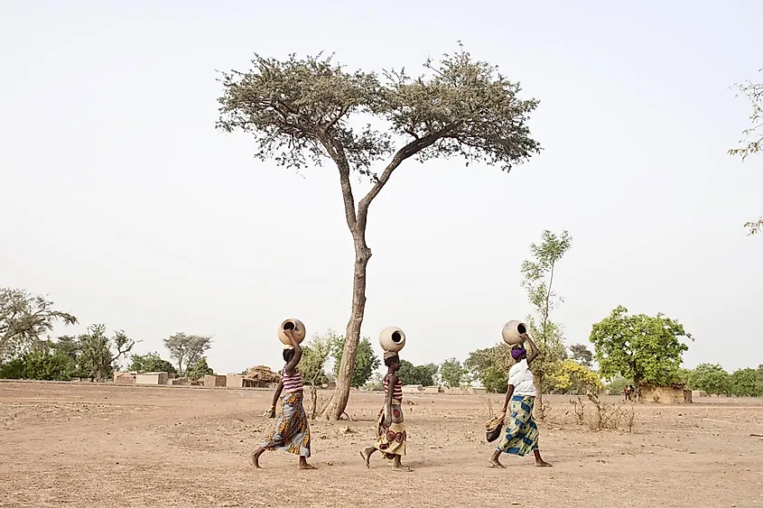 Women carrying clay pots to collect water in Poa, Burkina Faso